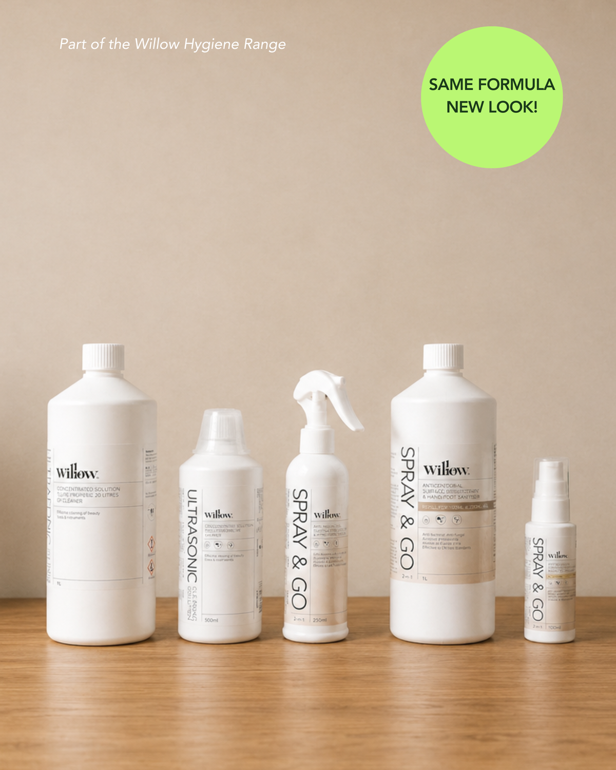 Five white Willow brand toiletry bottles and sprayers arranged on a wooden surface against a beige wall, with a green circular badge reading 'SAME FORMULA NEW LOOK!' in the top right.