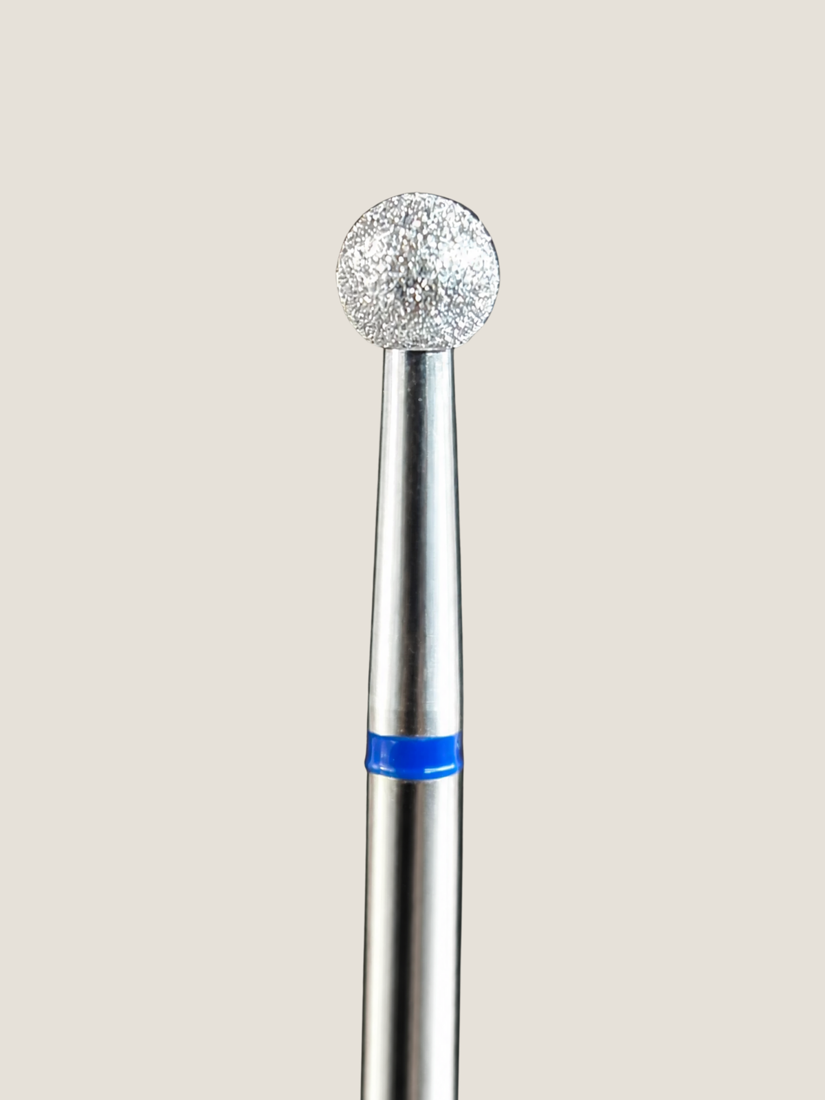 a close up of a platinum e-file bit a medium ball bit used to polish the cuticle area