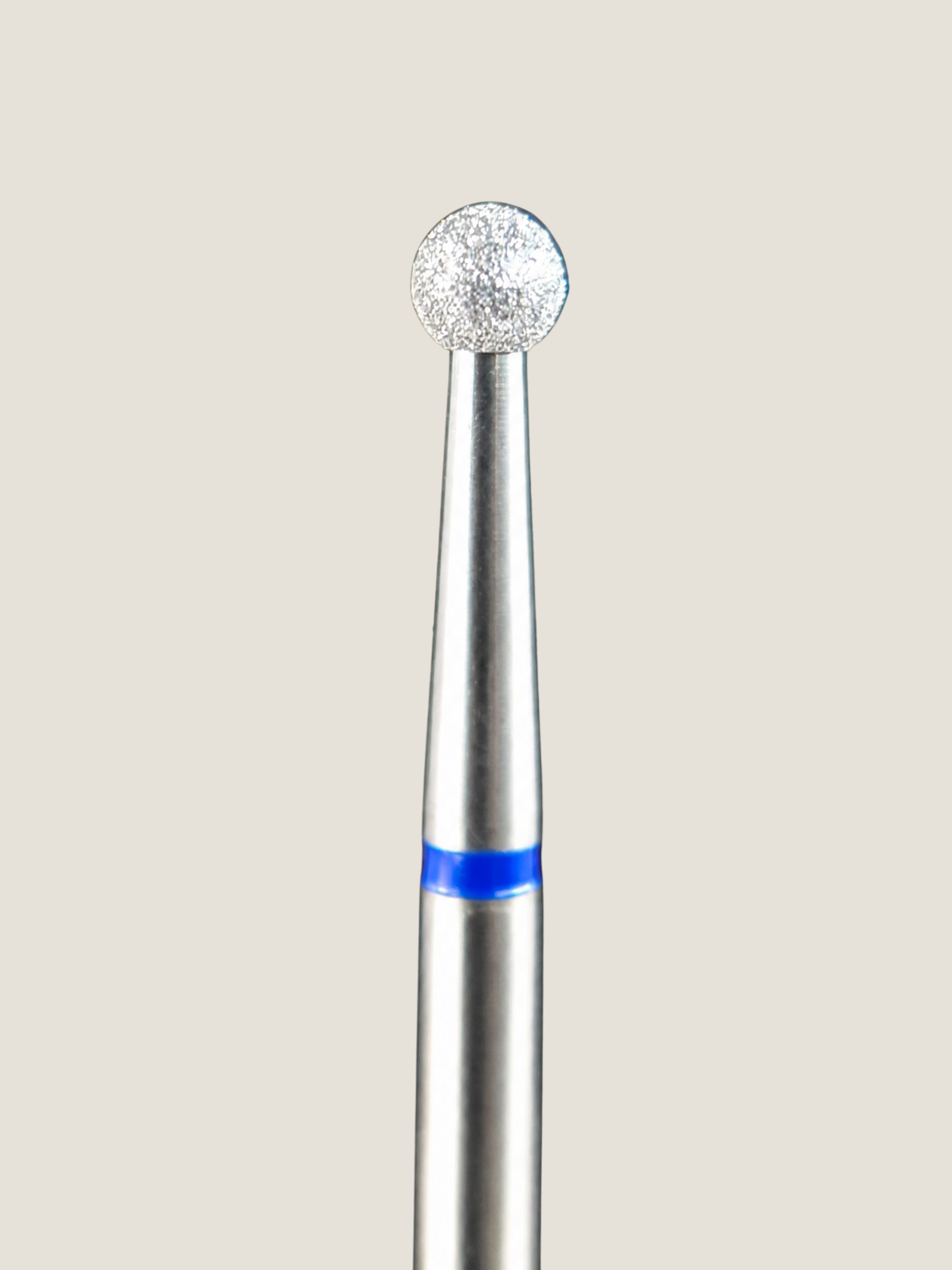 a close up of a platinum e-file bit . A ball shaped bit used for removing cuticle 