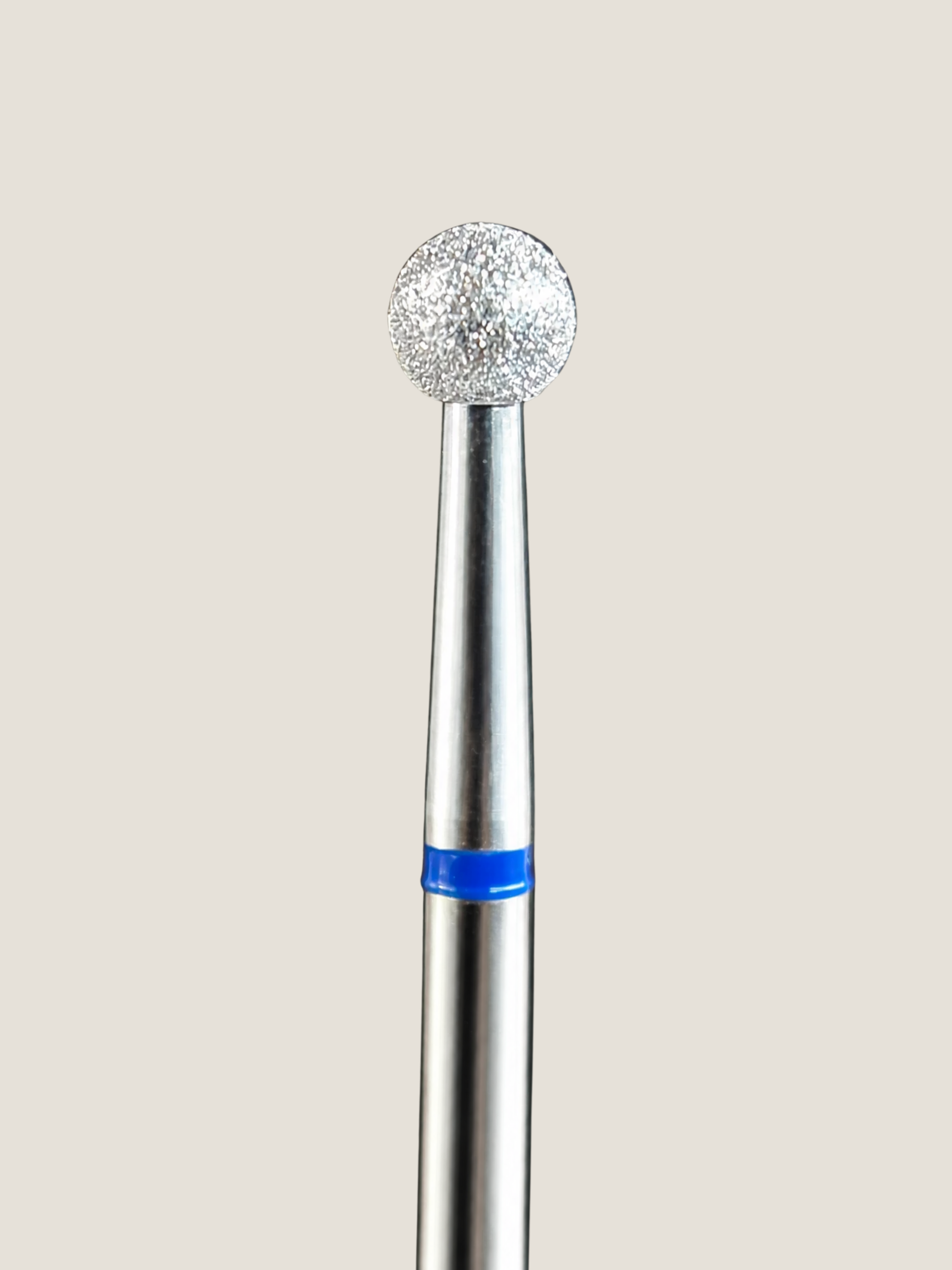 a close up of a platinum e-file bit a medium ball bit used to polish the cuticle area 
