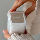 a hand holding a box of Willow lint free wipes with a flip top lid 